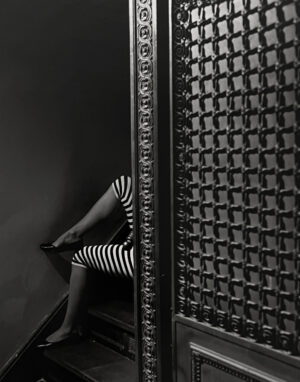 A woman sitting on the ground in front of a wall.