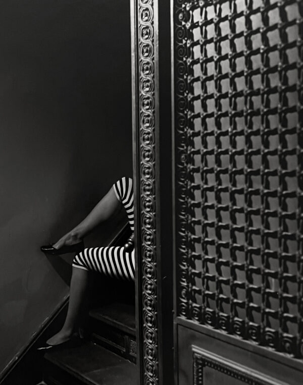 A woman sitting on the ground in front of a wall.