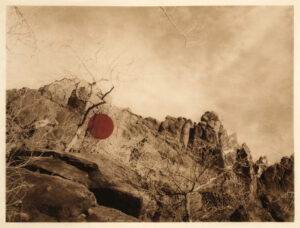 A red sign on top of a rock formation.