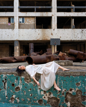 A woman in white dress laying on the ground.