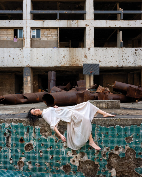 A woman in white dress laying on the ground.