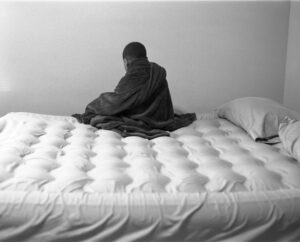A person sitting on top of a bed.