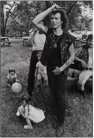 A man standing in the grass with other people.