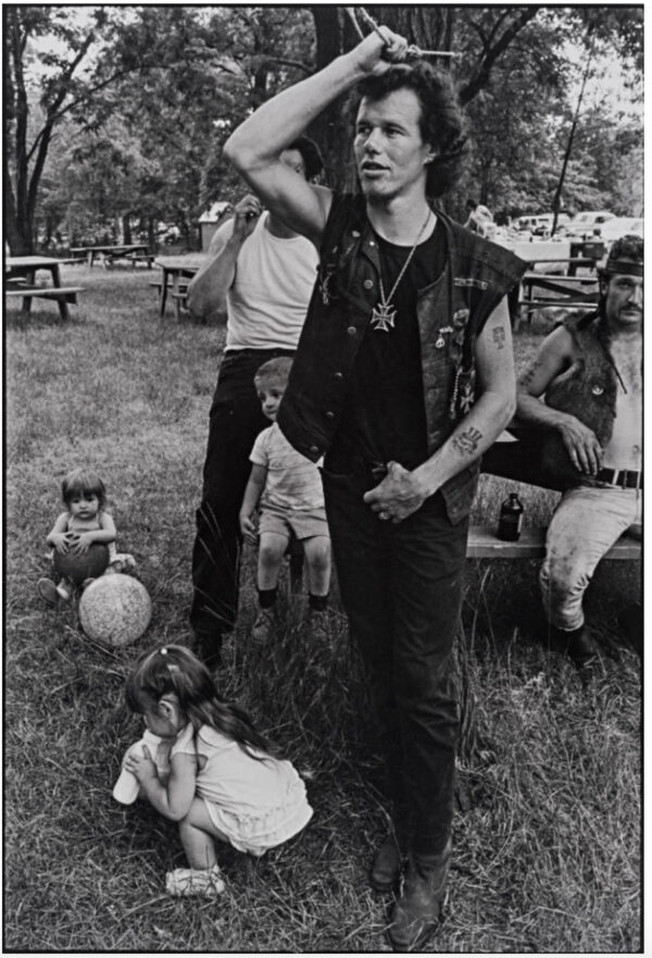 A man standing in the grass with other people.