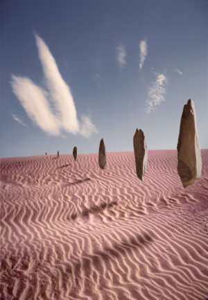 A group of tall stone statues in the desert.