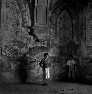 A boy standing in front of an old wall.