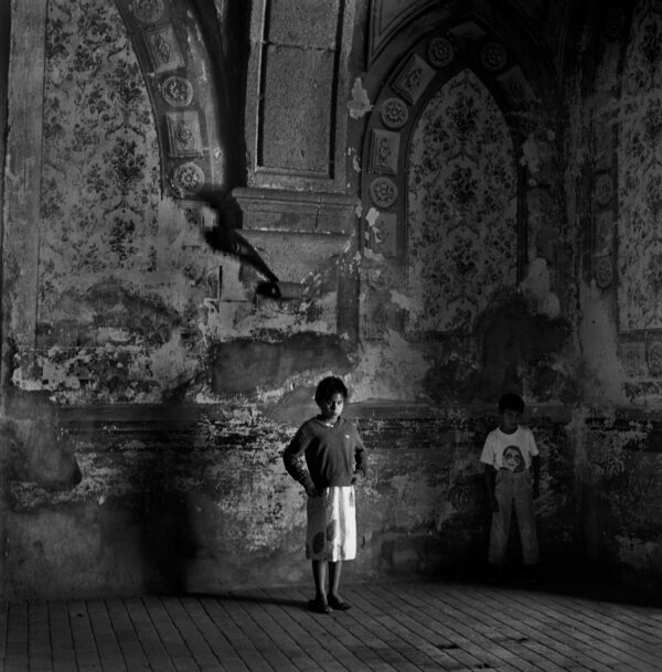 A boy standing in front of an old wall.
