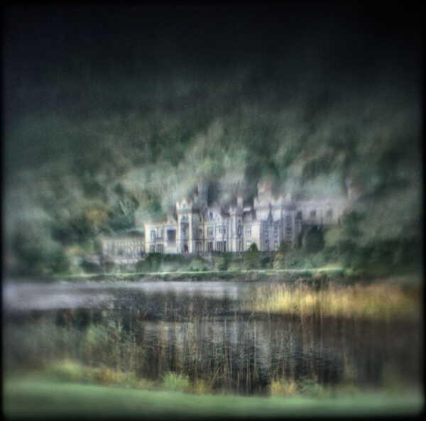 A blurry photo of an old castle with trees in the background.