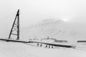 A group of people skiing on the snow covered ground.