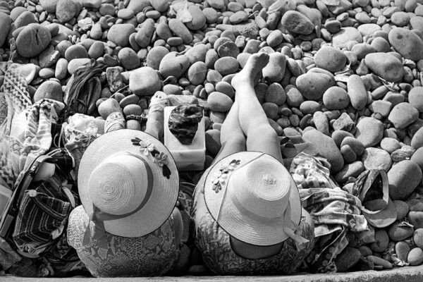 Two people laying on the ground with hats