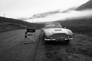A car parked on the side of a road next to a chair.