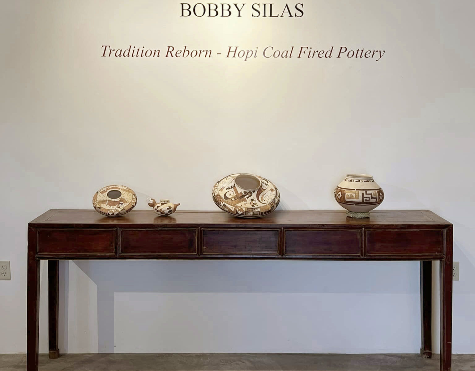Hopi pottery display with wooden table.