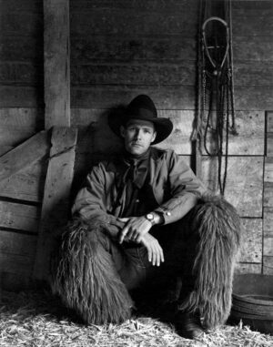 A man sitting on top of a chair wearing a hat.