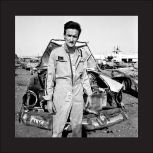 A man standing next to an old car.
