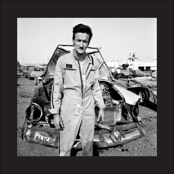 A man standing next to an old car.