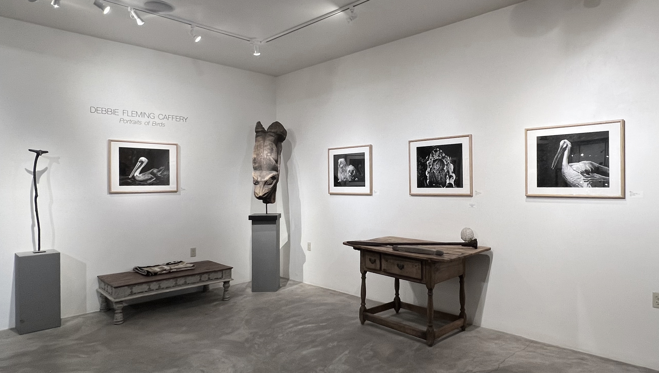 A woman and man sitting on the ground in front of a bench.