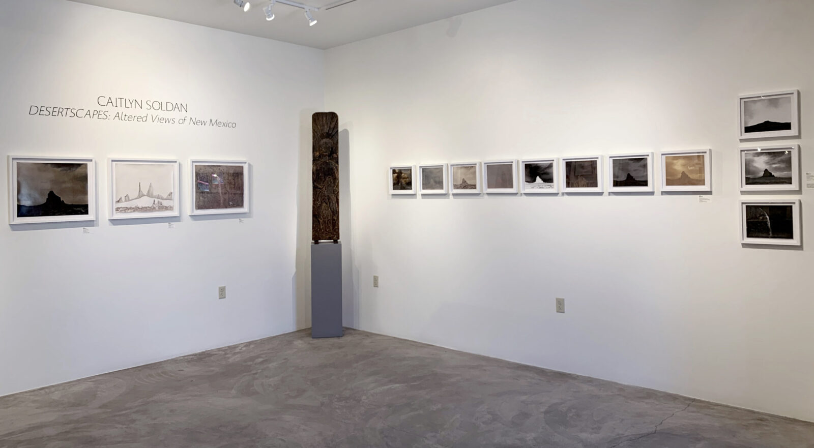 A woman and man sitting on the ground in front of a bench.