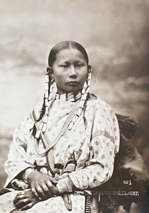 A woman in native dress with long braids.