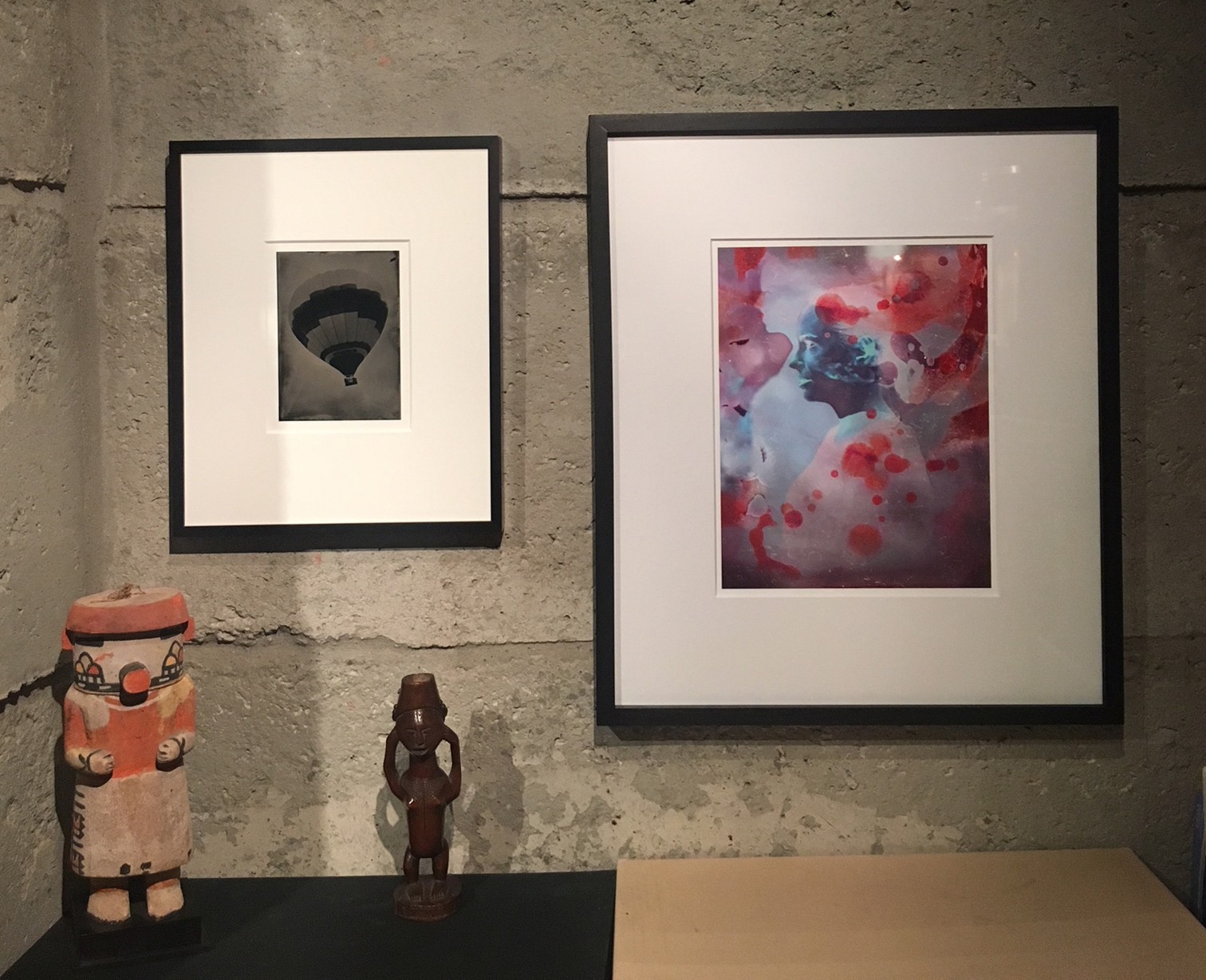 A woman and man sitting on the ground in front of a bench.