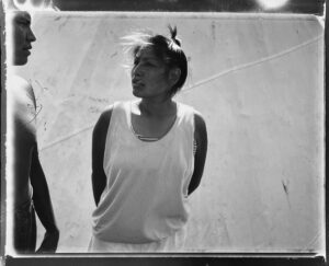 A woman standing next to another person on a skateboard ramp.