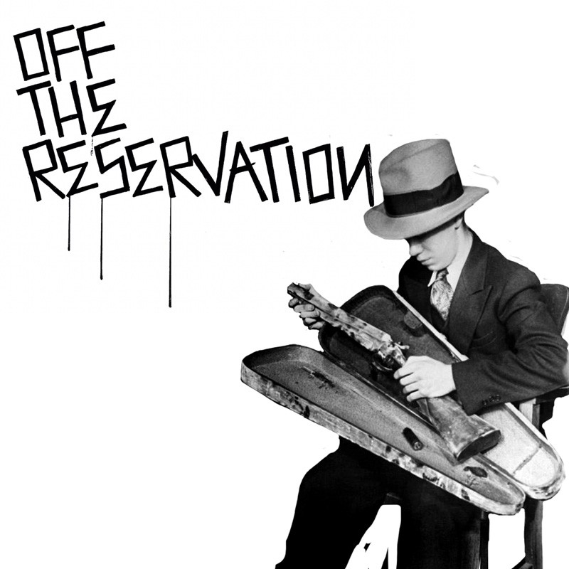 A woman and man sitting on the ground in front of a bench.