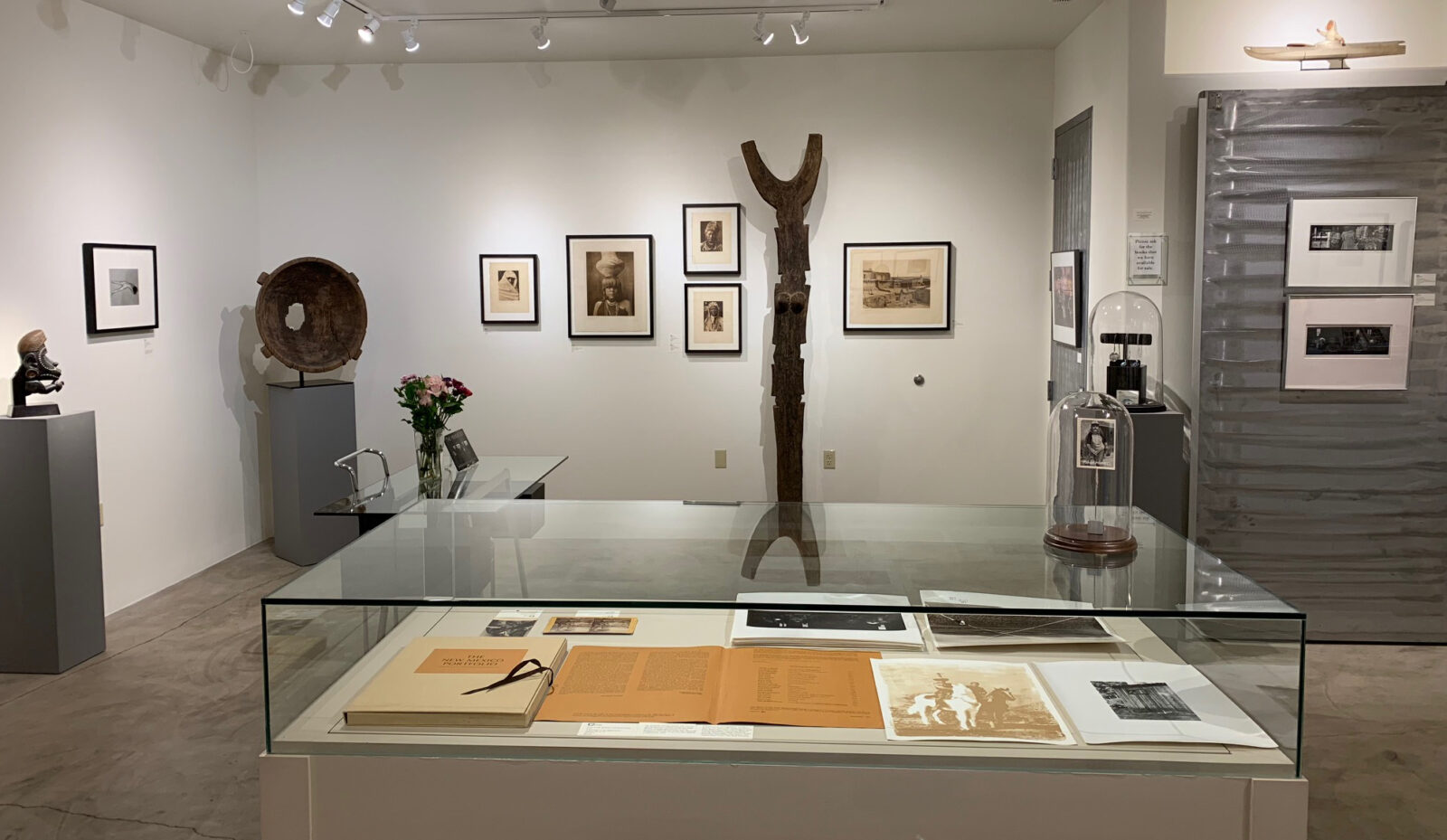 A woman and man sitting on the ground in front of a bench.