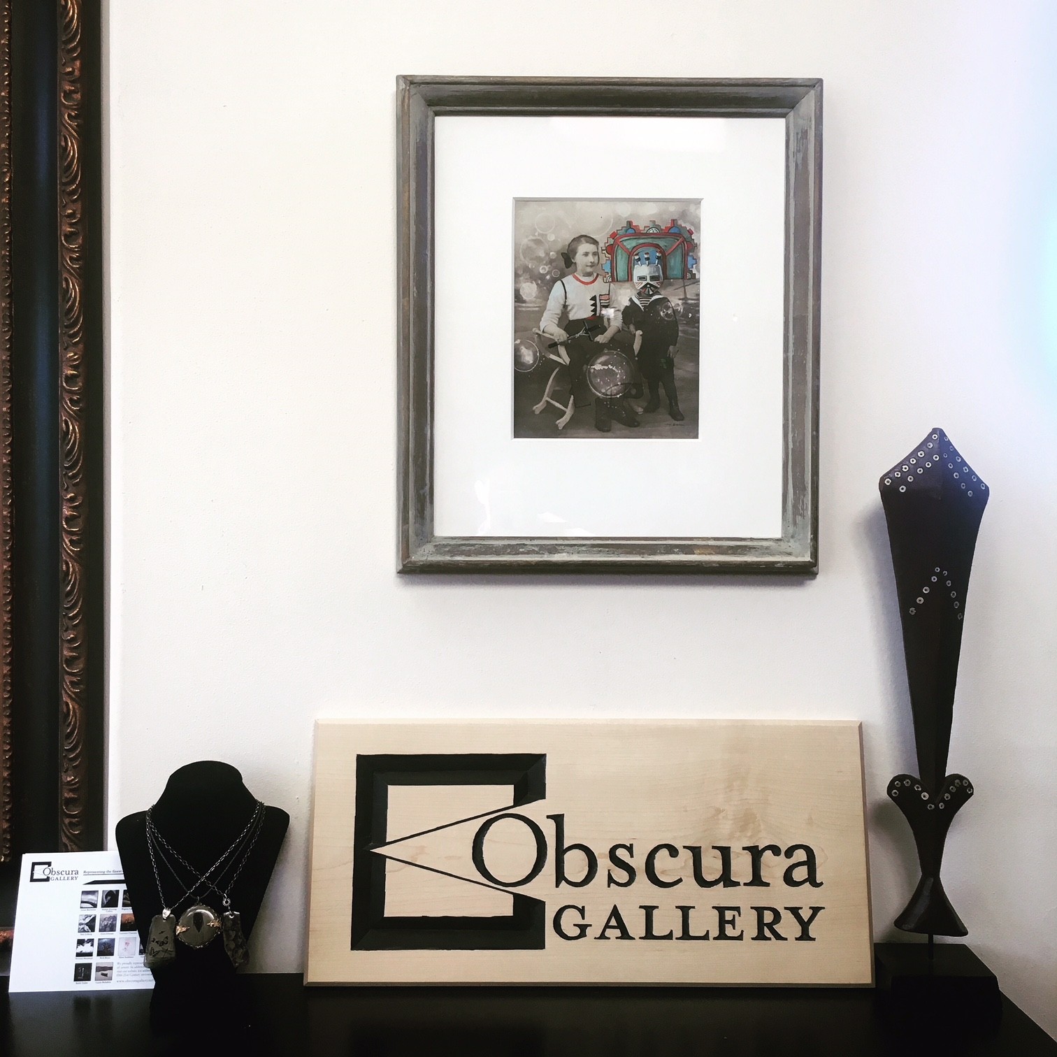 A woman and man sitting on the ground in front of a bench.