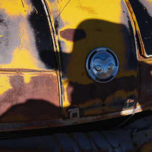 A close up of the side of an old yellow car.