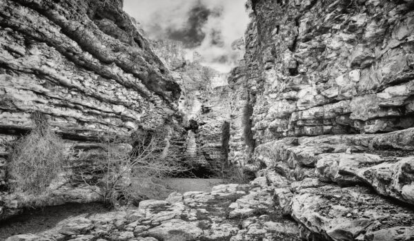 A black and white photo of rocks in the middle of a canyon.