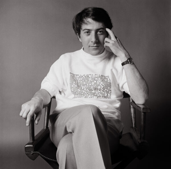 A man sitting in a chair with his hand on the head.