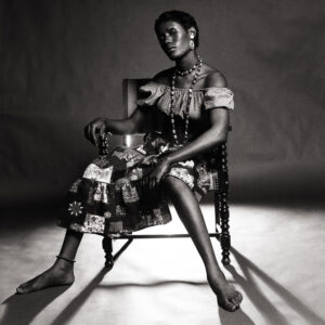 A woman sitting on a chair in the dark.