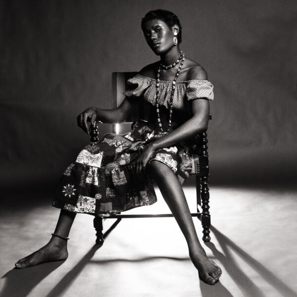 A woman sitting on a chair in the dark.