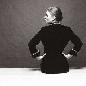 A woman in black dress sitting on the ground.