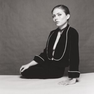 A woman sitting on the ground wearing black and white.