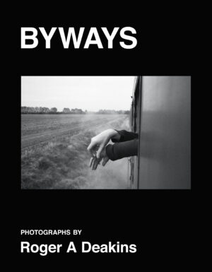 A black and white photo of a hand on the side of a train.
