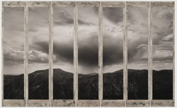 A black and white photo of mountains with clouds