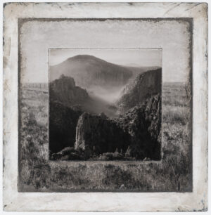 A black and white photo of mountains with fog