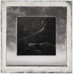 A black and white photo of mountains with clouds