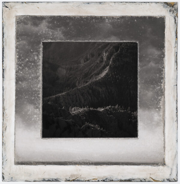 A black and white photo of mountains with clouds