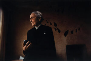 A man in black jacket holding a book.