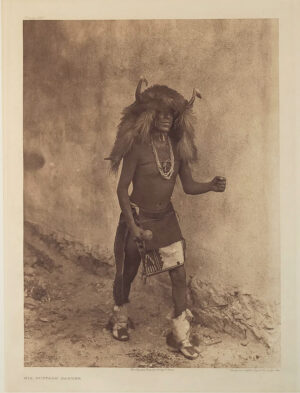 A man in native dress standing on the ground.