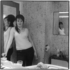Two women in a bathroom looking at each other.