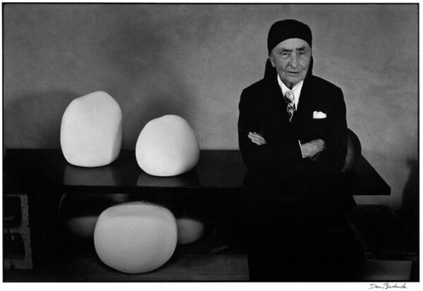 A man in suit and tie next to some white objects.