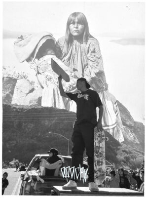 A man standing on top of a chair in front of a large statue.