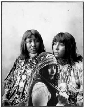 Two women in native dress and a woman with long hair.