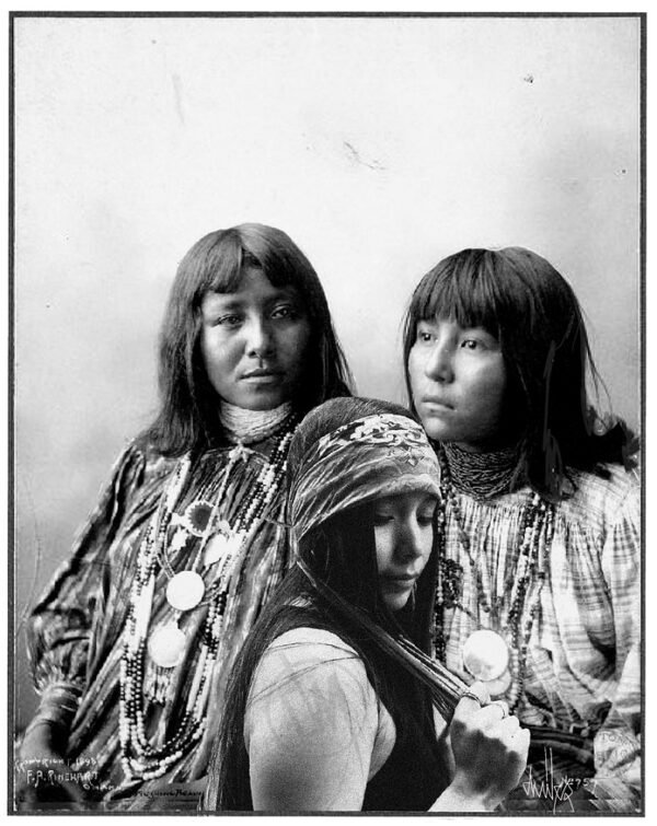 Two women in native dress and a woman with long hair.