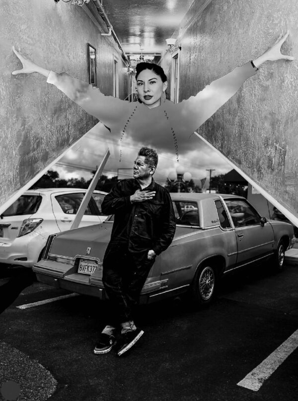 A man holding an umbrella in front of a car.