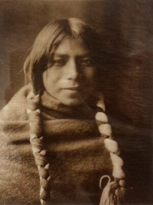A man with long hair and a beard wearing a blanket.