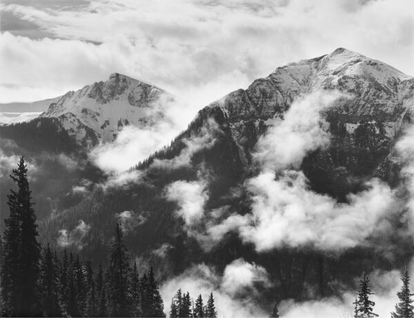 A black and white photo of mountains with clouds
