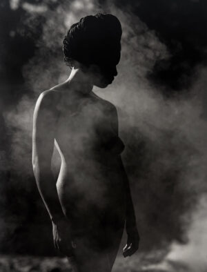A woman standing in the middle of smoke.